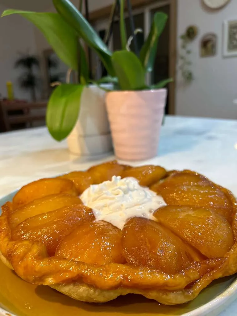 A golden Apple Tarte Tatin with caramelized apples in a cast-iron skillet